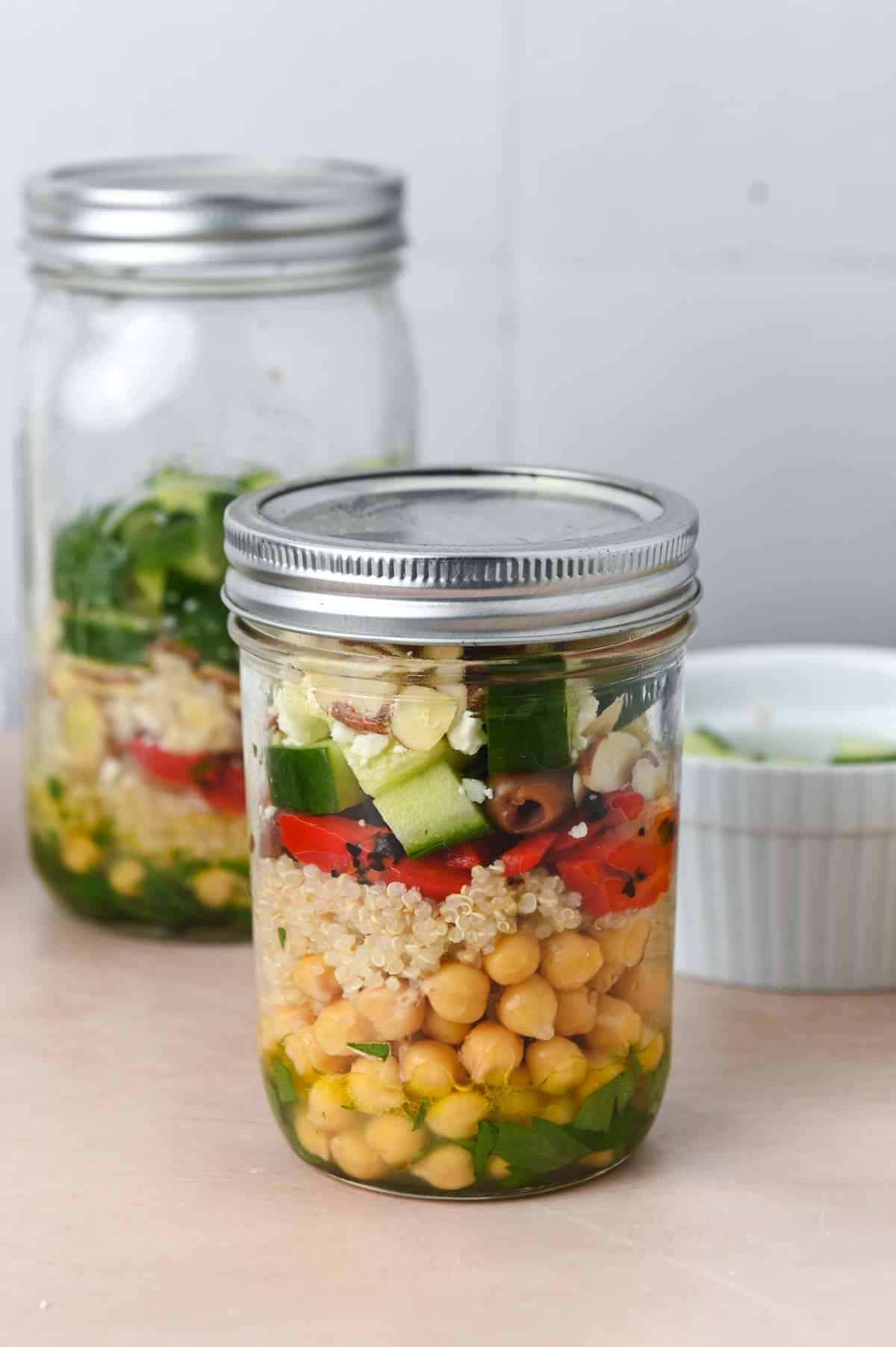 Glass jar with quinoa chickpea salad inside.