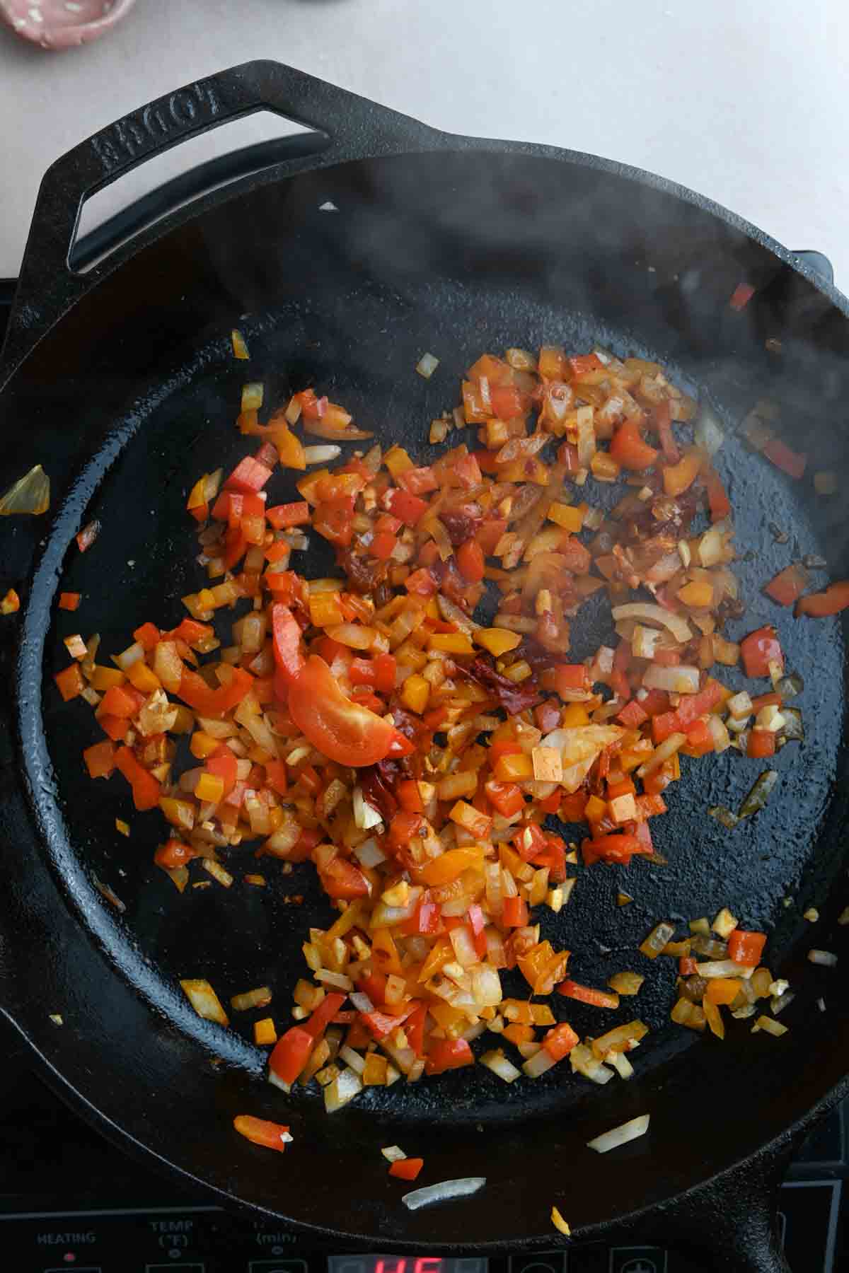 Softened peppers and onions in cast iron skillet.