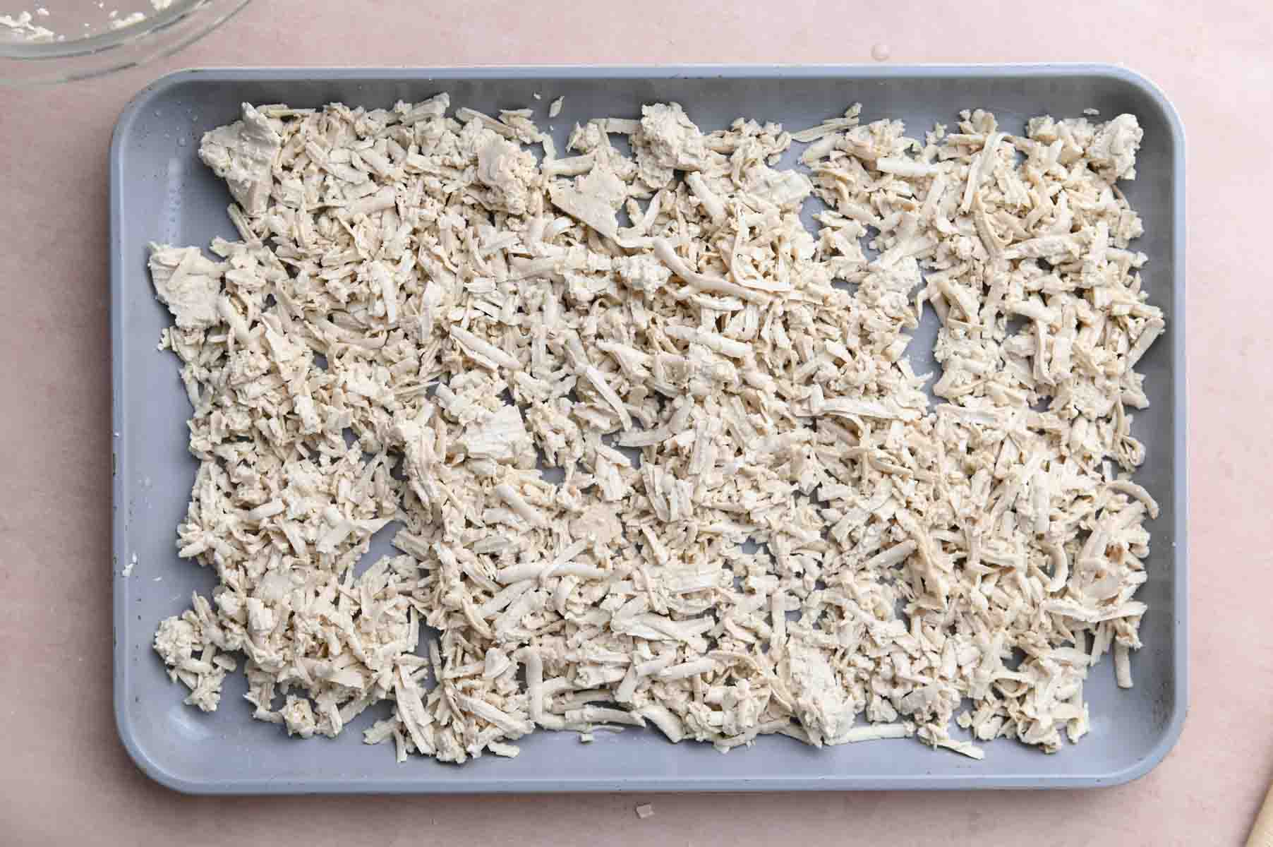 Shredded tofu on a baking sheet before baking.