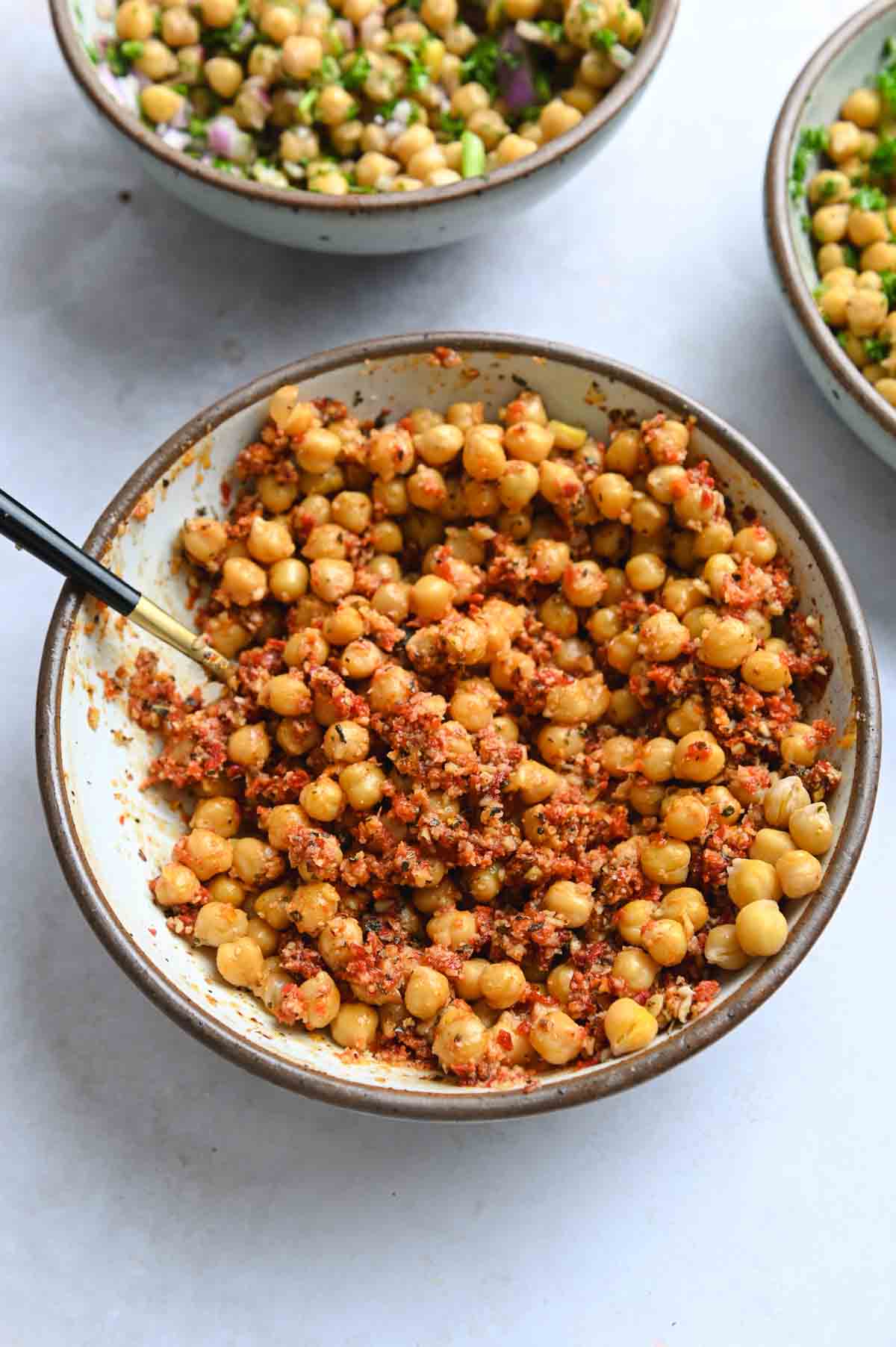 Sun-dried tomato marinated chickpeas in a white bowl.