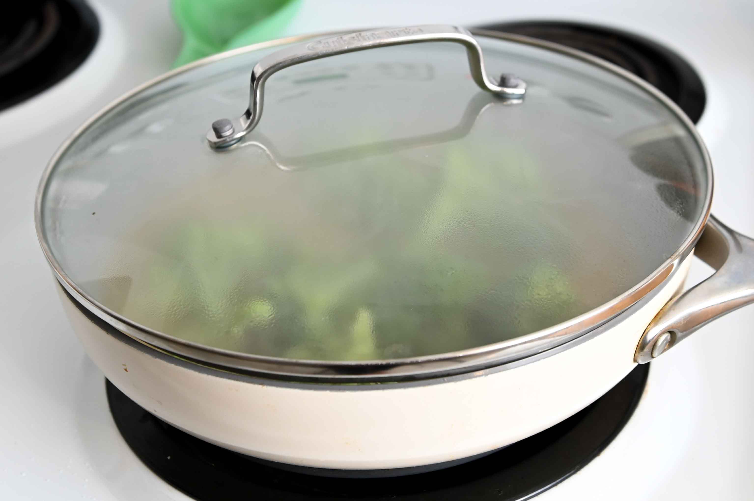 White skillet covered with a lid.