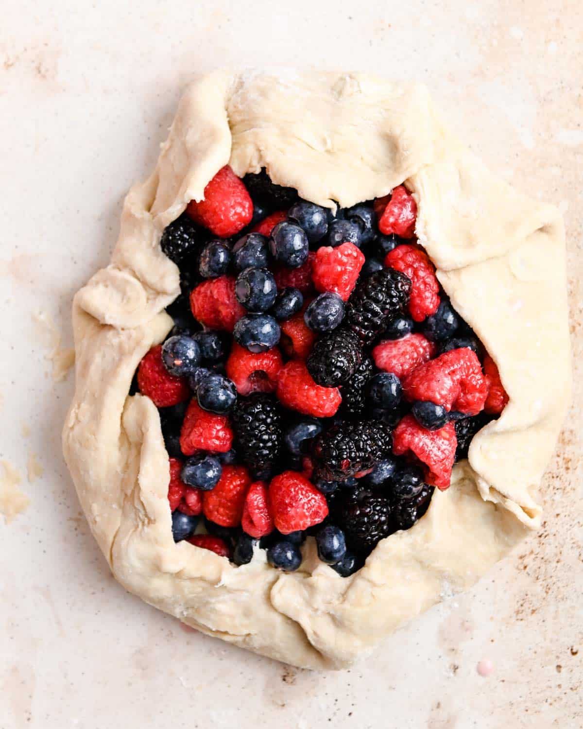 Galette dough filled with mixed berries before cooking.