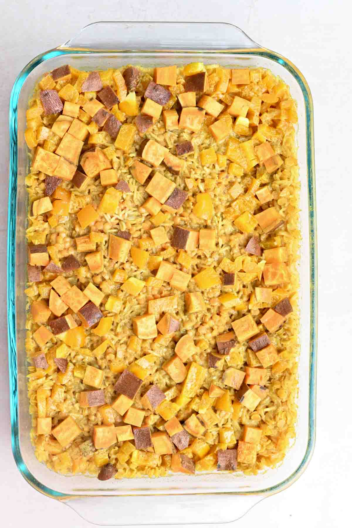 Glass casserole dish filled with cooked lentil, rice, and sweet potato casserole.
