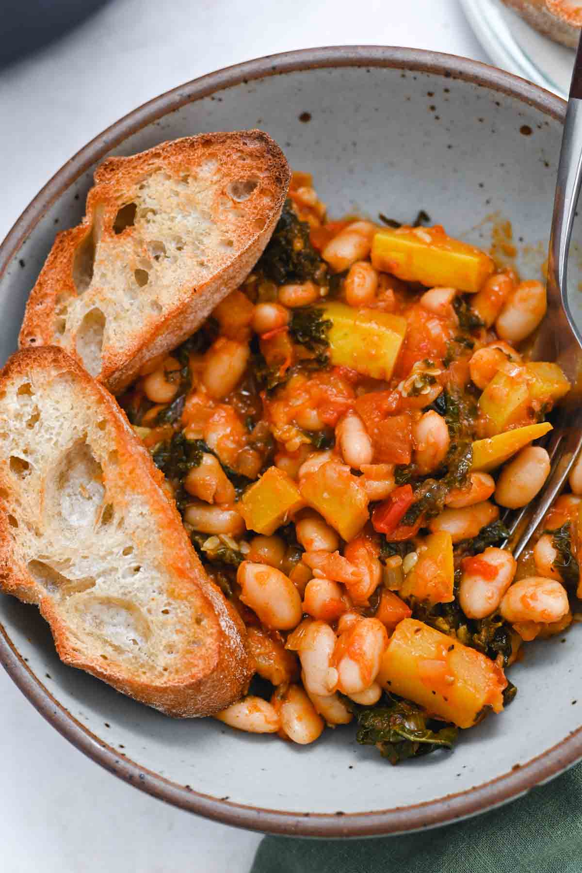Close up of beans and toast in a gray bowl.