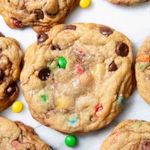 M&M chocolate chip cookie surrounded by mini M&Ms and more cookies.