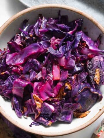 White bowl filled with purple roasted cabbage.