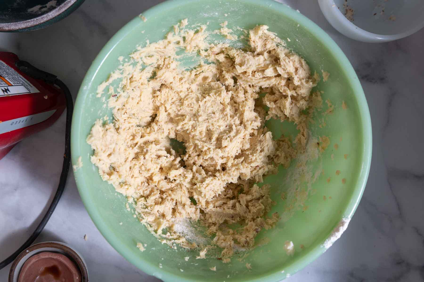 Almond cookie dough in jadeite green bowl.