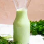 Green dressing in a glass carafe.