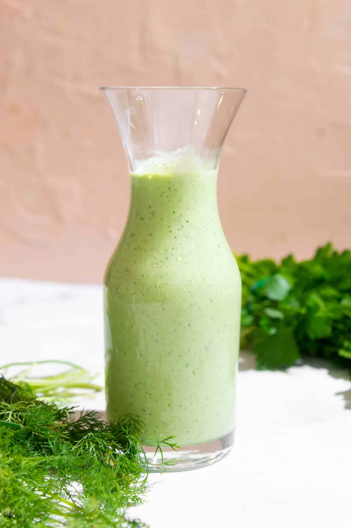 Green dressing in a glass carafe.