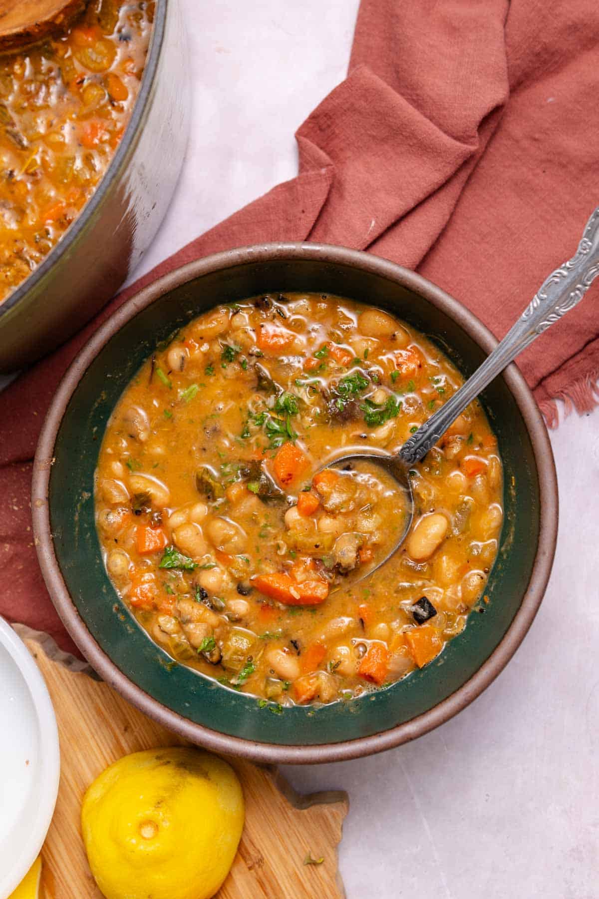 Green bowl with white bean soup and a spoon in it.