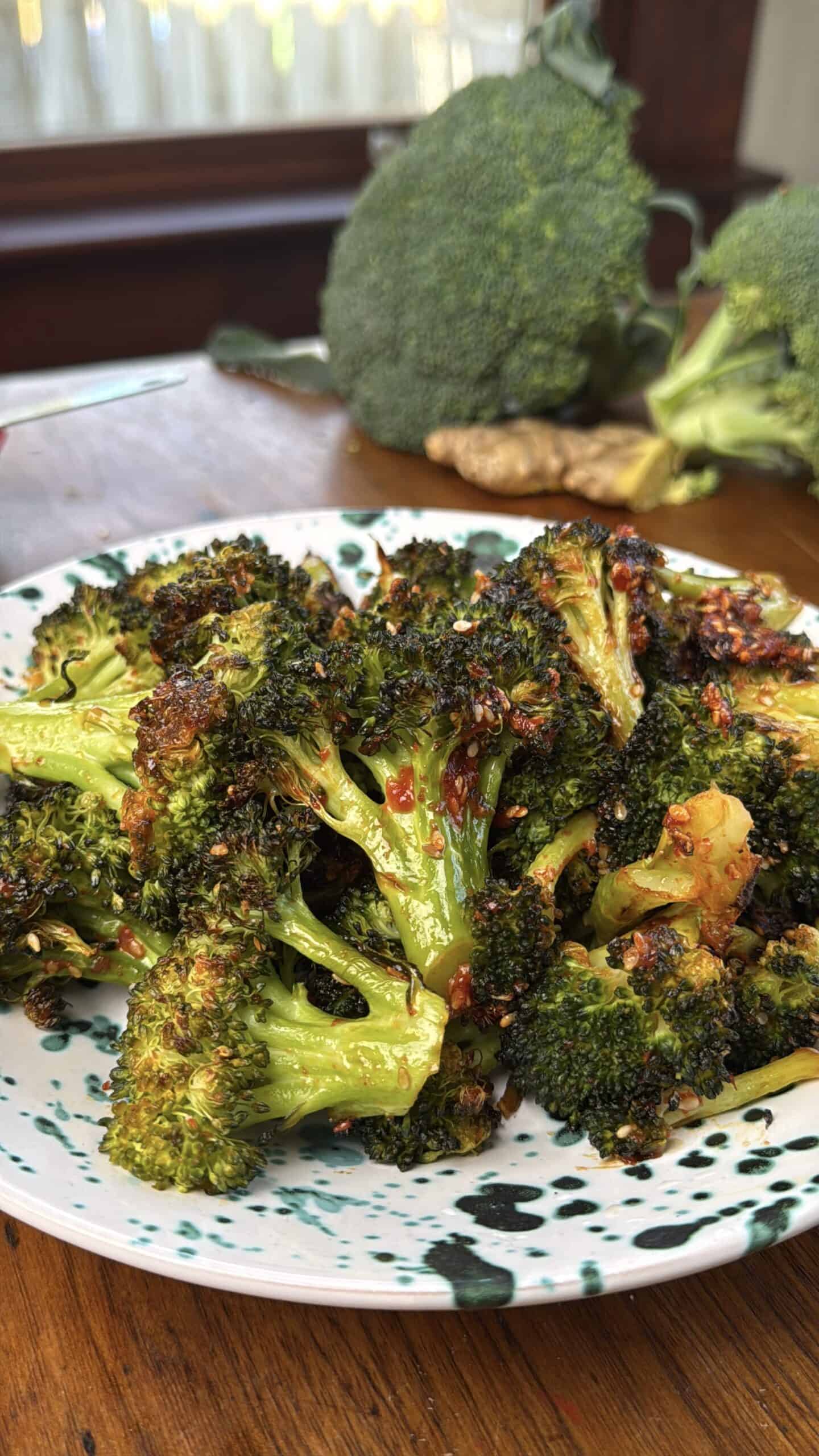 Roasted broccoli in a blue-speckled bowl.