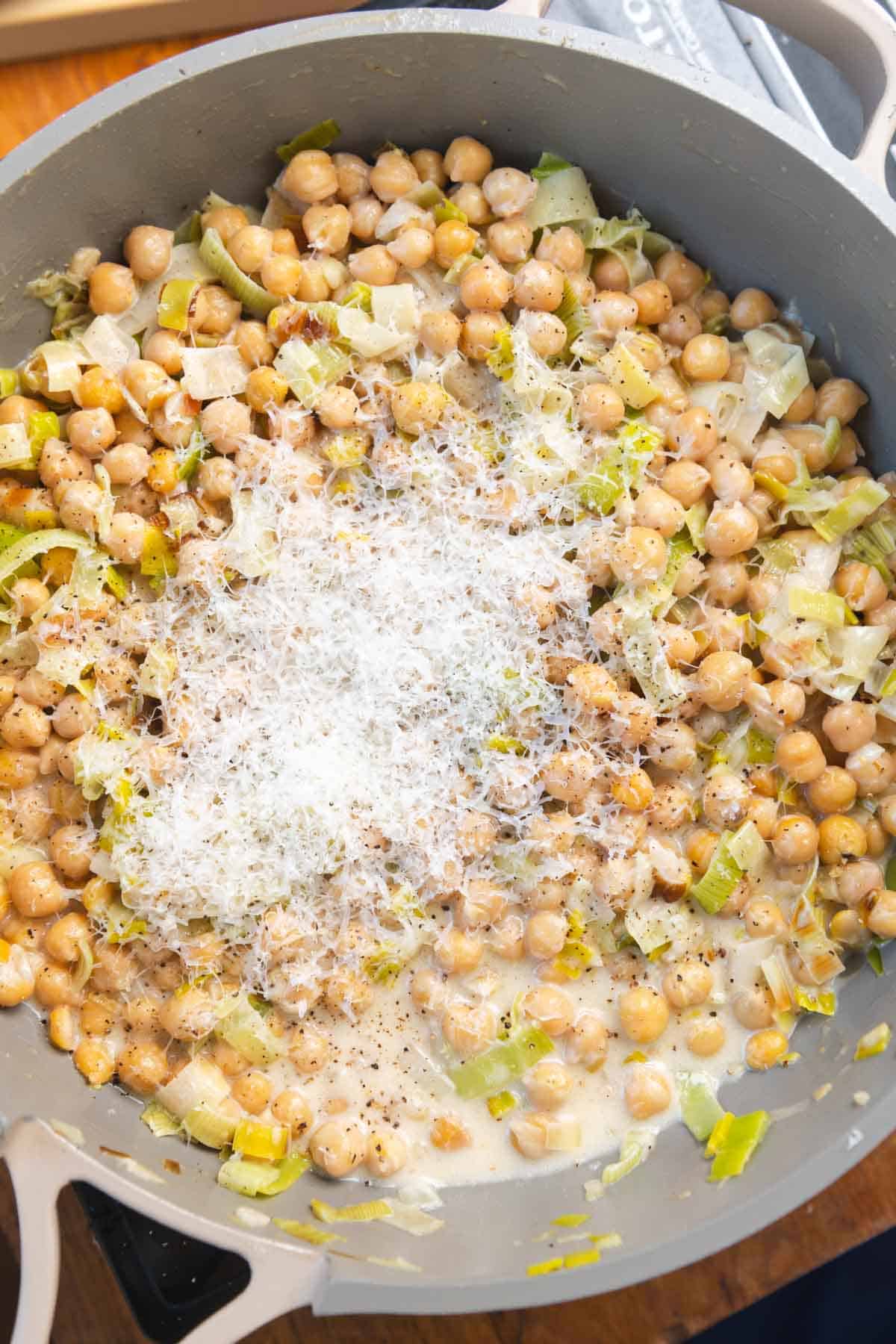 Chickpeas topped with finely grated Parmesan in a gray pot.