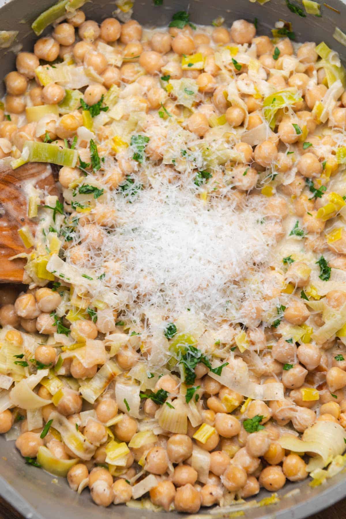 Close up of chickpeas topped with finely grated parmesan.