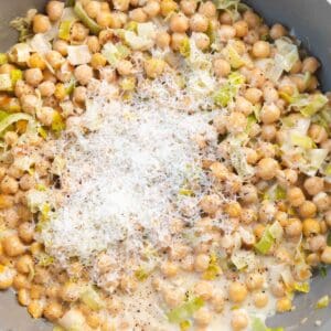 Chickpeas topped with finely grated Parmesan in a gray pot.
