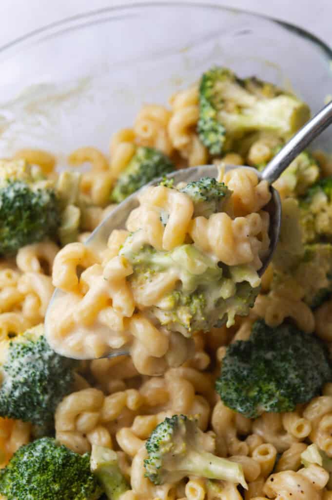 Serving spoon lifting a scoop of macaroni out of the baking dish.