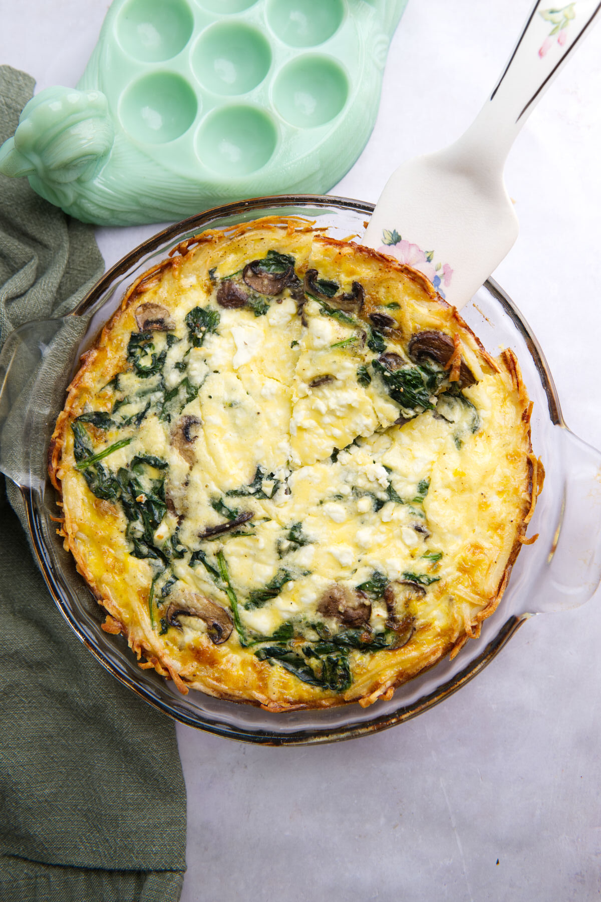 Overhead view of hashbrown quiche in a glass pie dish.
