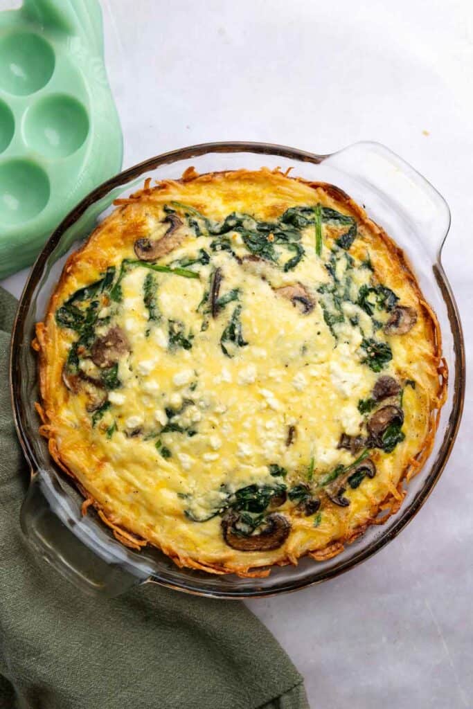 Overhead view of hashbrown quiche in a glass pie dish.