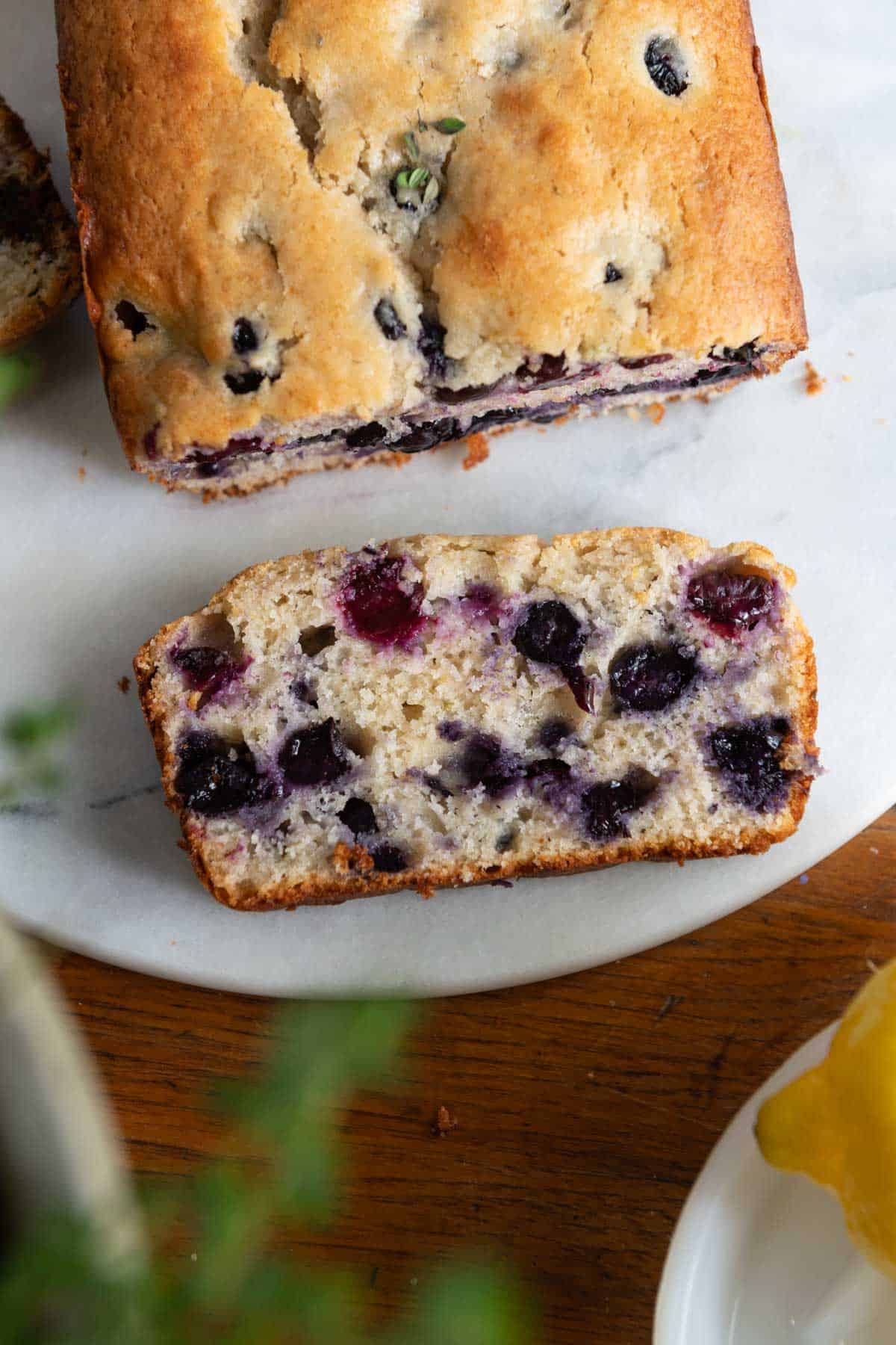 Slice of blueberry bread on a marble circle.