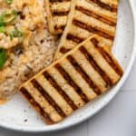 Close up of grilled tofu slab with char marks on it.