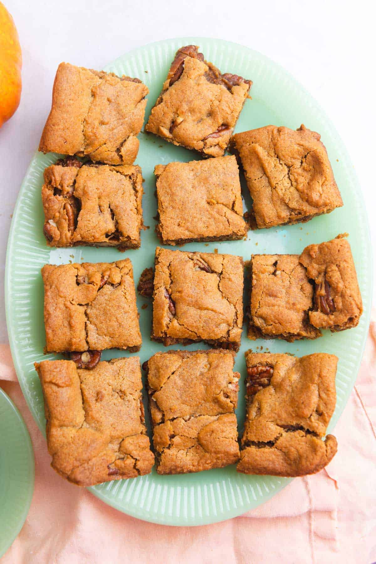 Close up of pumpkin bars on an oval-shaped jade green platter.