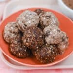Energy balls in a pink bowl on a pink background.
