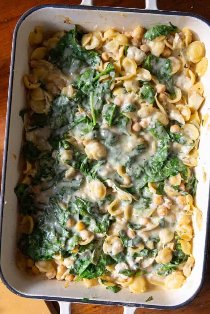 Close up of pasta bake with spinach and melted Parmesan cheese.